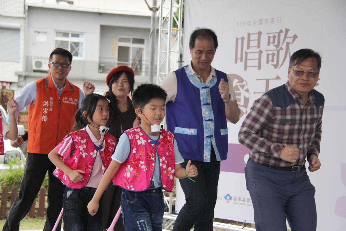 張志明副縣長(後排右二)和多位來賓上臺，與小朋友載歌載舞，表演客家歌謠，相當逗趣。