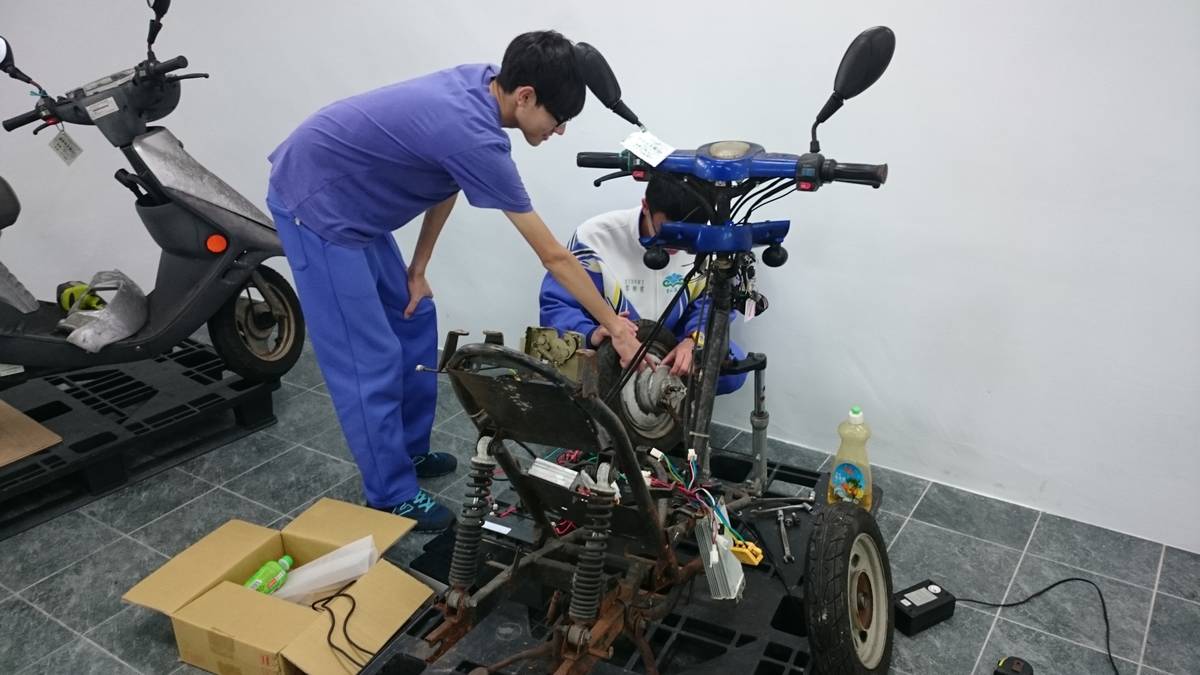 學生們拆解廢棄的電動摩托車，改裝成三輪車