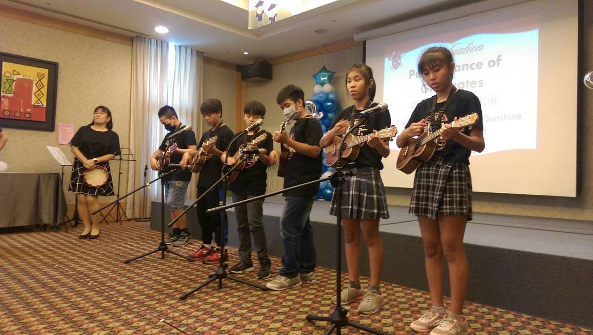 畢業生彈奏烏克麗麗演唱英文歌曲You are my Sunshine。

