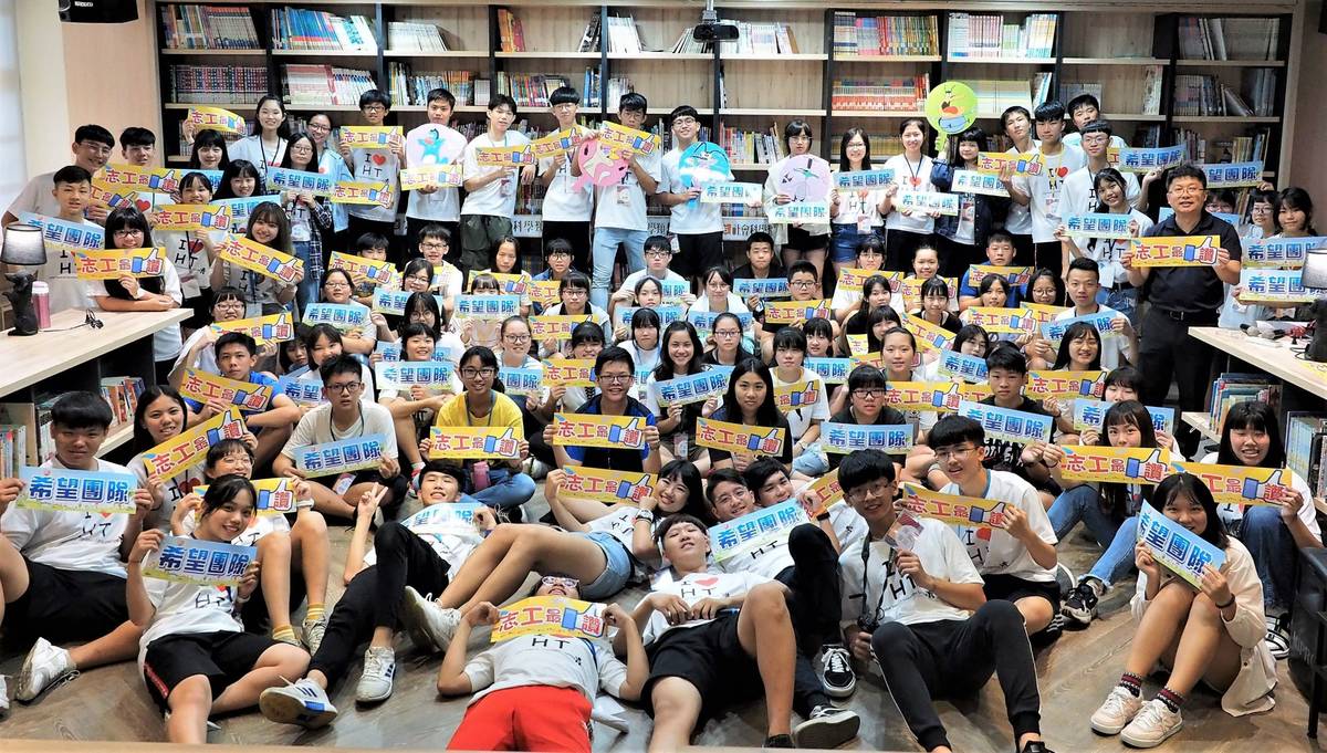 南興國小校長柯伯儒與高中志工學生於國小圖書館的大合照
