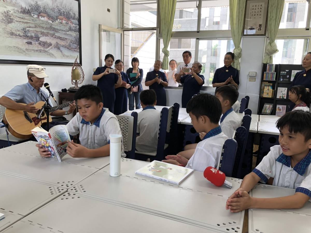 卑南族音樂歌謠創作者陸森寶的兒子陸光朝，自彈自唱，小朋友有的在樂聲中讀書，有的隨著歌聲打拍子。