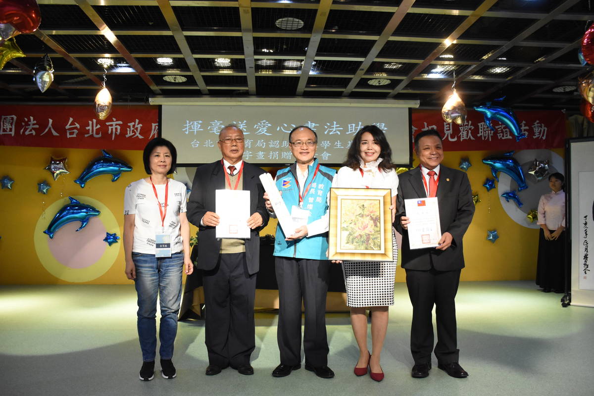 台北市政府教育局認助清寒學生基金會舉辦相見歡活動，讓受助學生與認助者見面，圖為贈書畫給基金會的儀式。