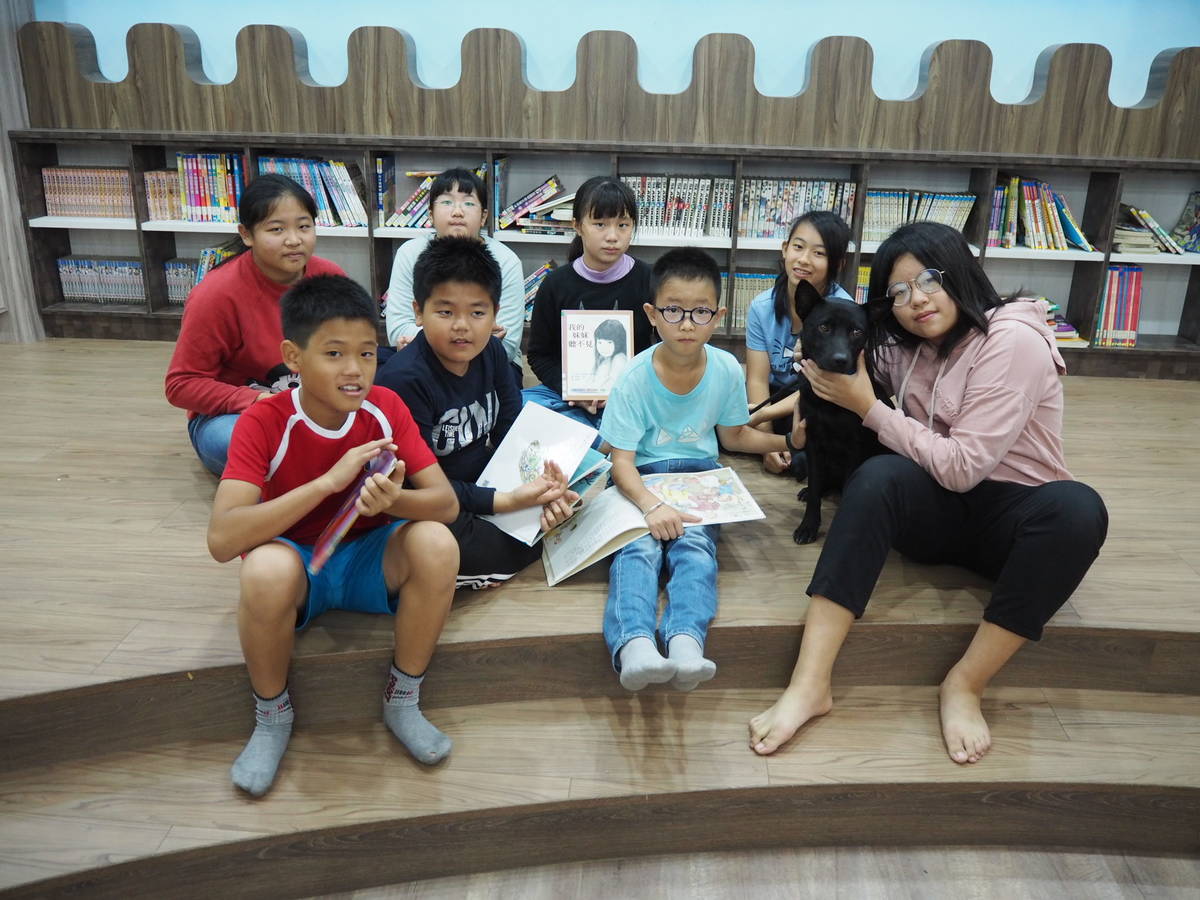 彰化縣文德國小校狗歐爸與學生們於校內圖書室共讀的合照