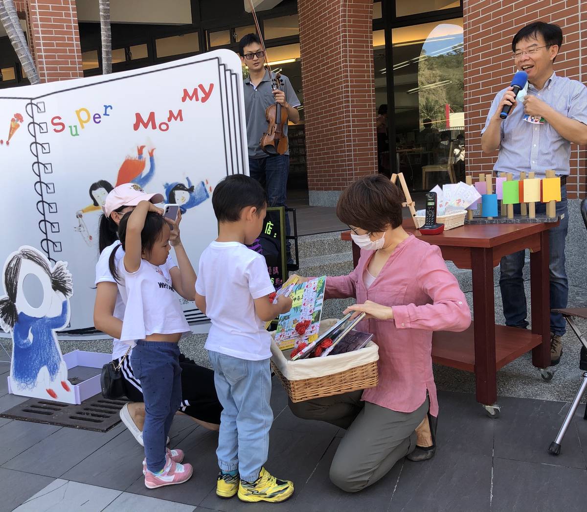 饒縣長親自頒贈繪本給愛上圖書館前五名小小鐵粉，文化處長鍾青柏(右後)笑得眼睛瞇成一條線。