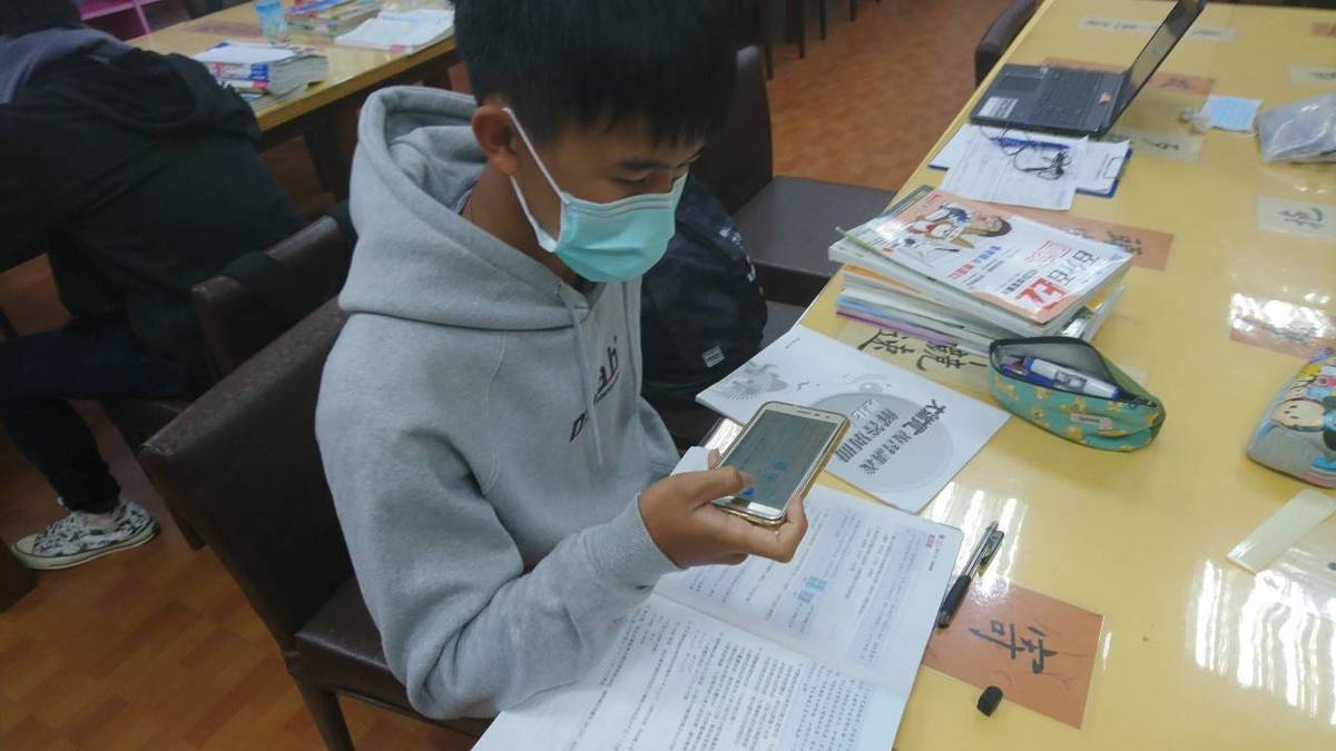 學生拿手機掃瞄題目發問。
