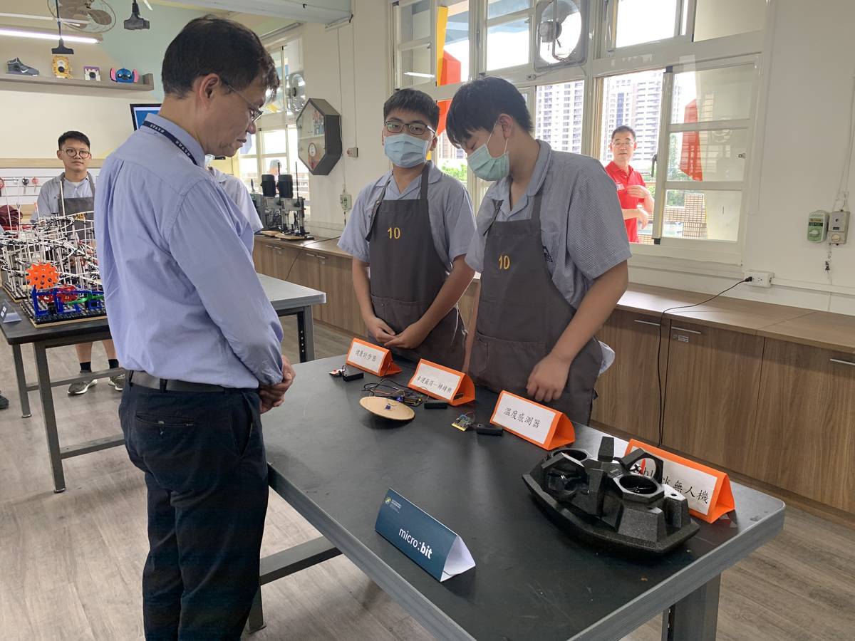 新泰國中學生向副局長蔣偉民介紹自己的作品。
