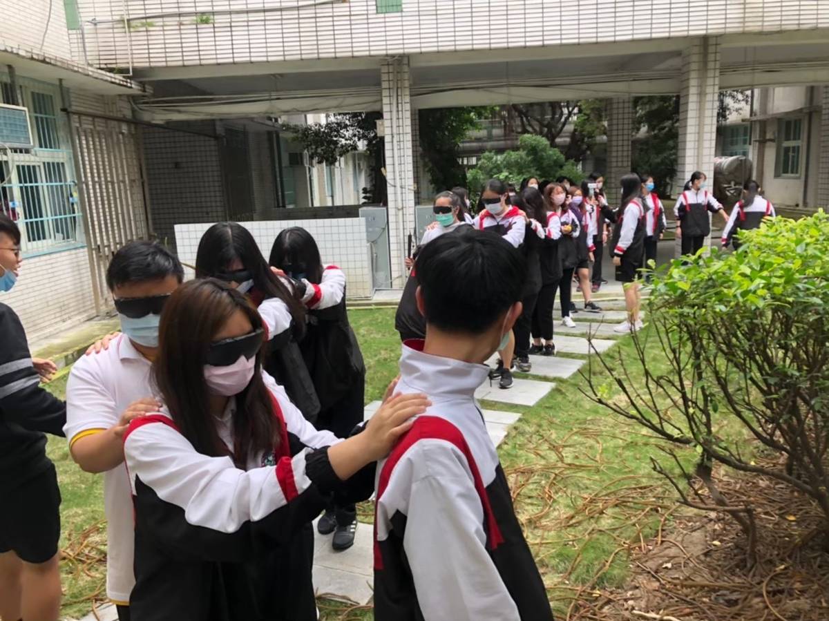 三重高中辦理視障體驗，蒙眼步行校園小徑。