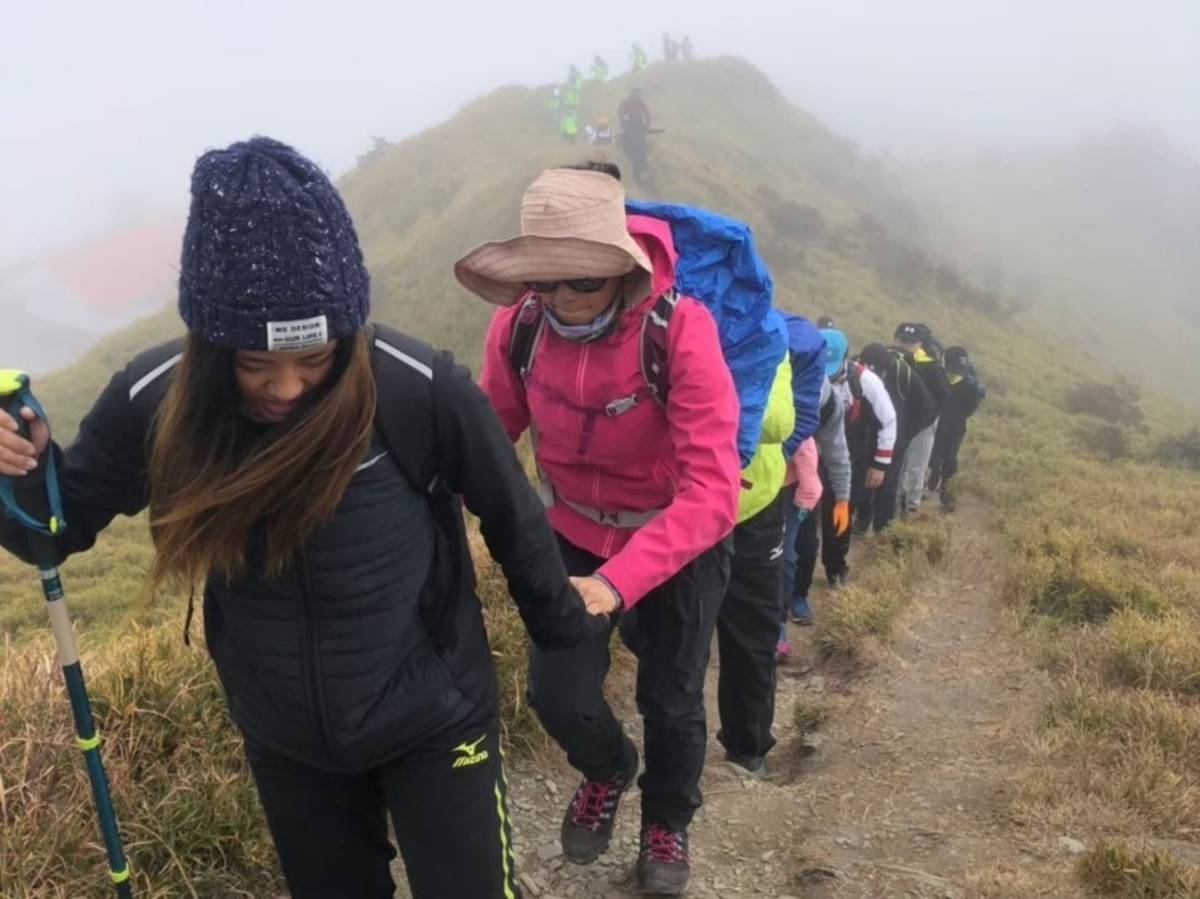 三重高中學生一路牽著視障者登上合歡山主峰。