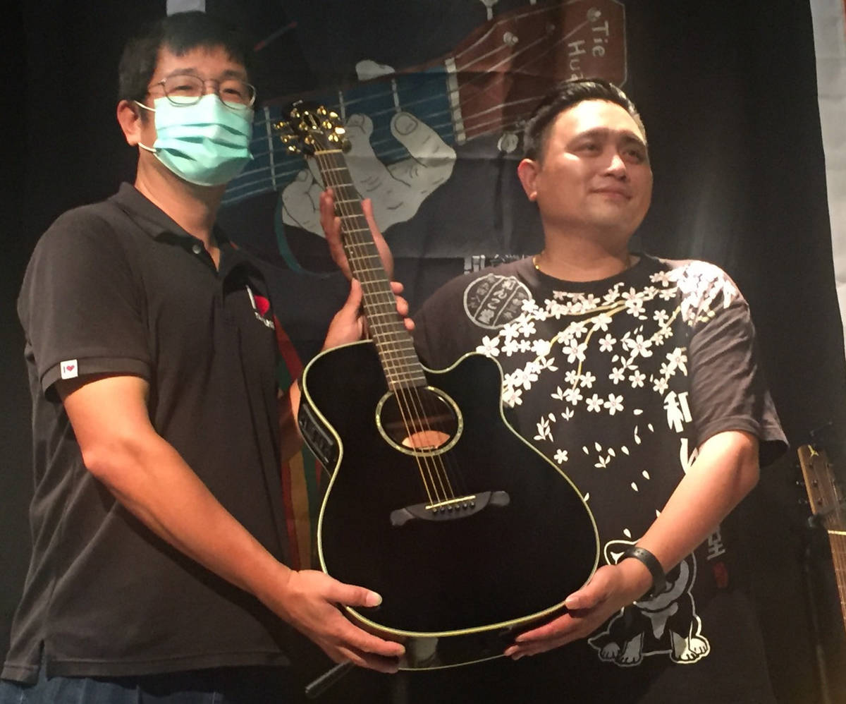 歌手吳昊恩(右)代表法麗達(Farida)公司將吉他捐贈給臺東縣政府，由文化處副處長劉俊毅接受。