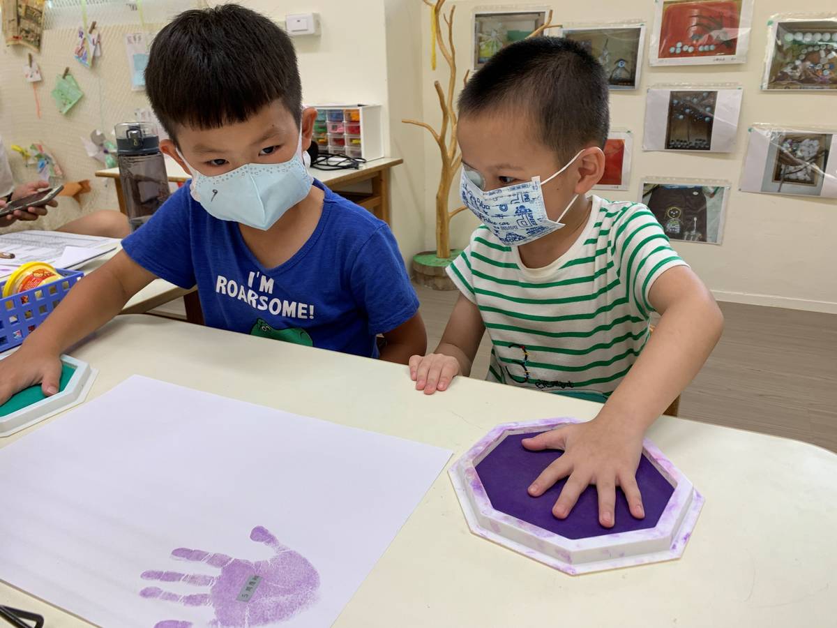 幼兒們開心的在新學期新希望圖卡蓋上小手印。
