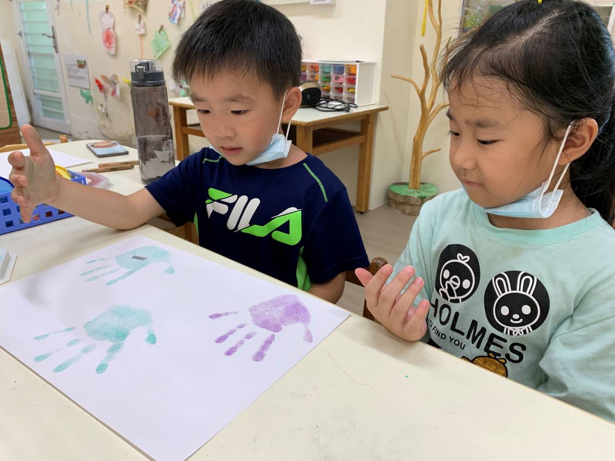 幼兒們開心的在新學期新希望圖卡蓋上小手印。