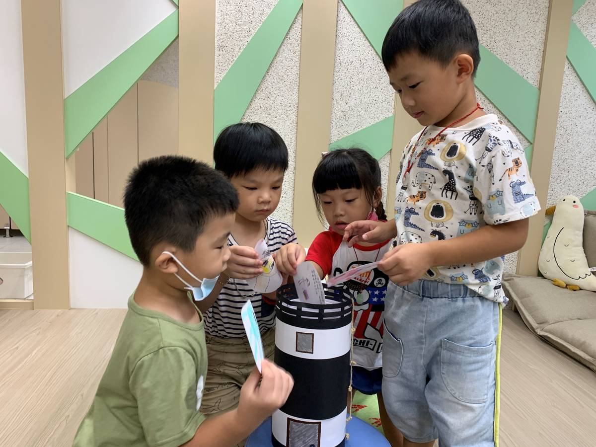 幼兒們將新學期新希望圖卡投入燈塔時空膠囊。