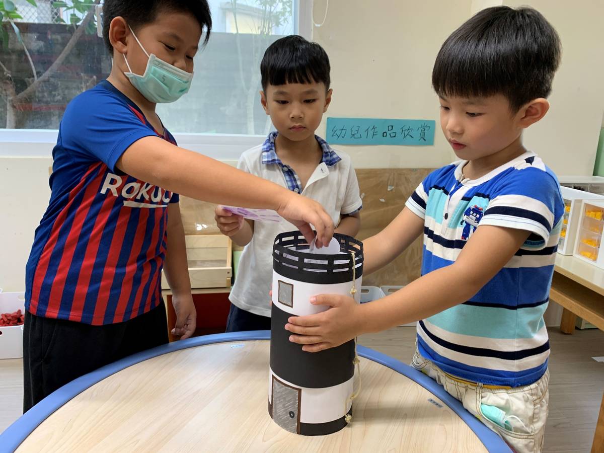 幼兒們將新學期新希望圖卡投入燈塔時空膠囊。