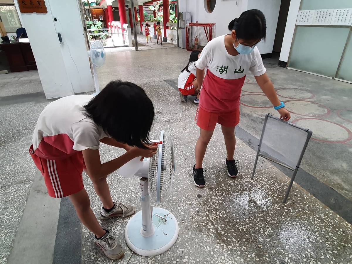 湖山國小學生以噴瓶和電風扇測試捕霧網蒐集水的效果