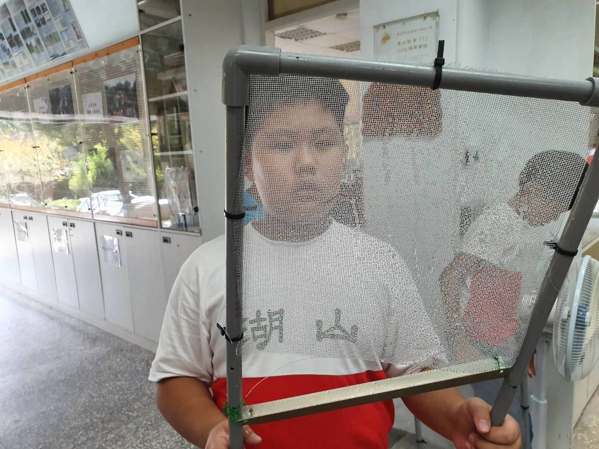 湖山國小學生測試捕霧網後在網線上看到水珠