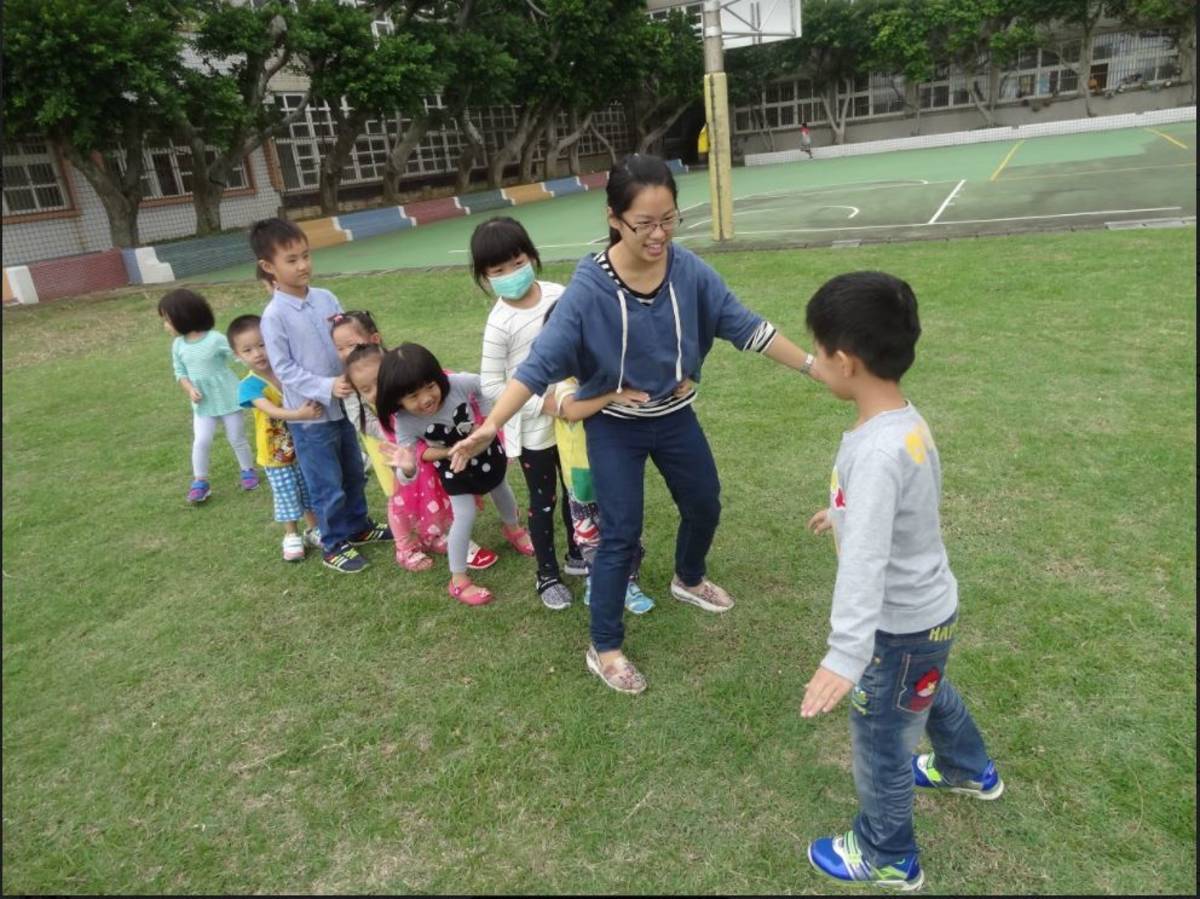 石門國小附設幼兒園凃宜婷老師與幼兒們一起遊戲。

