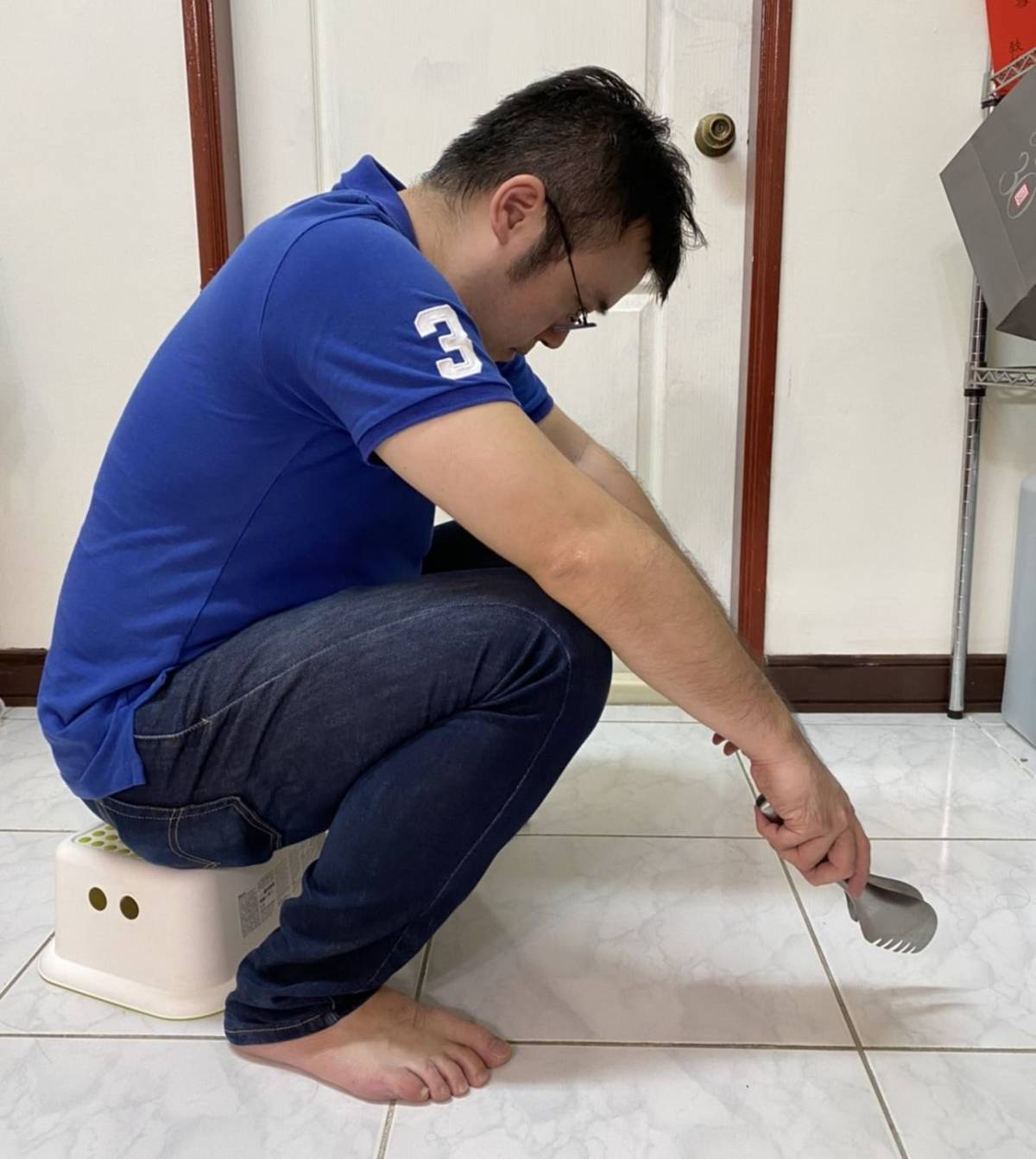光田綜合醫院骨科醫師嚴可倫示範民眾常見前傾彎腰的烤肉姿勢，會造成椎間盤壓力爆增而增添腰痛風險。