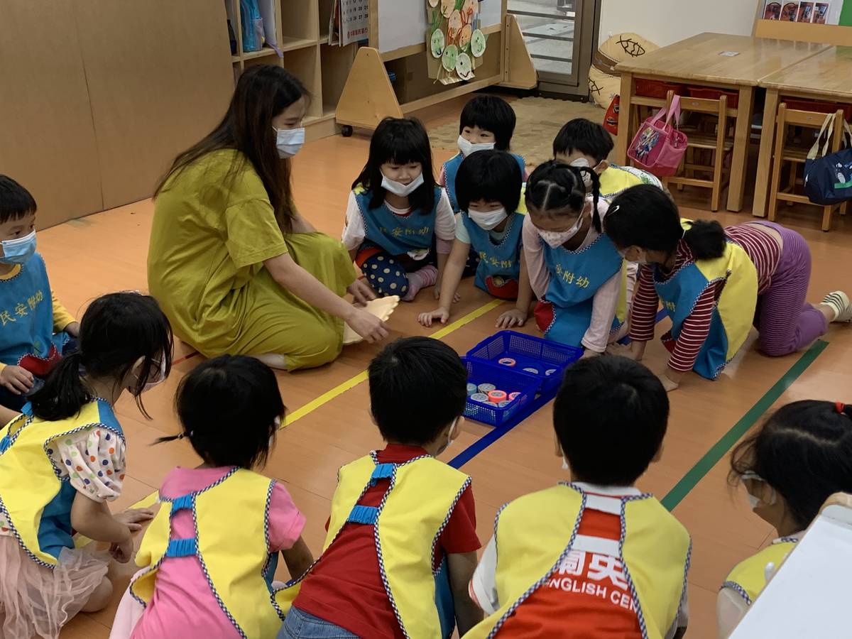 藝術家織女彤彤正在跟幼兒介紹如何把點連起來的遊戲。