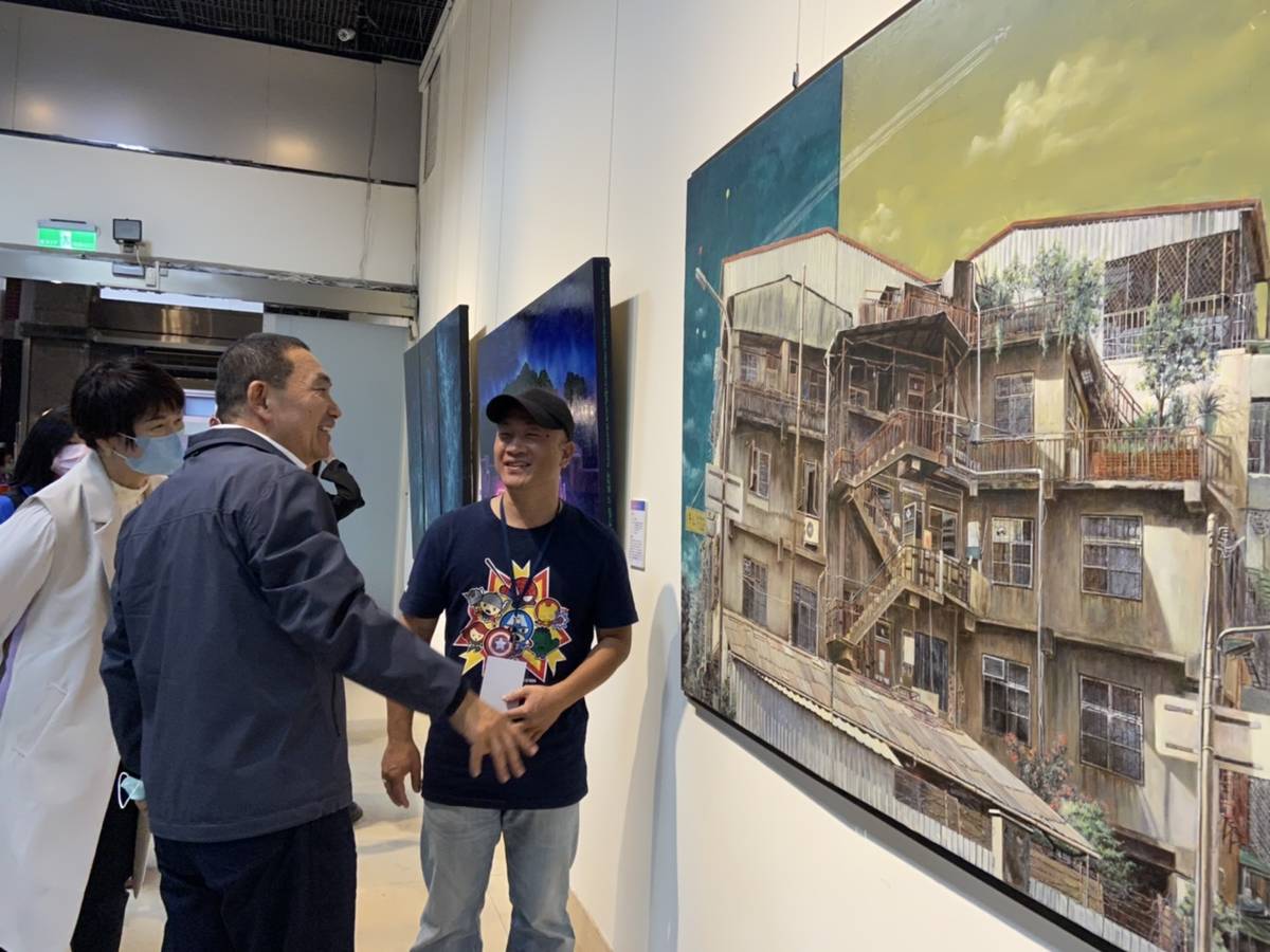 市長侯友宜與油畫類第3名作者洪俊銘一同討論其得獎作品「城市印象」。