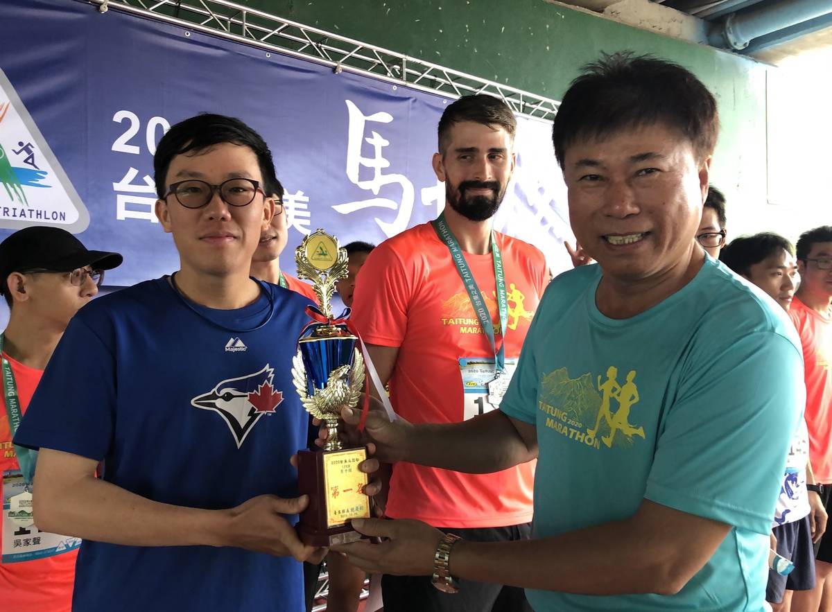從小就愛運動的陳麒丰獲得健跑組冠軍，從臺東縣體育會理事長陳銘風手中接下獎杯。