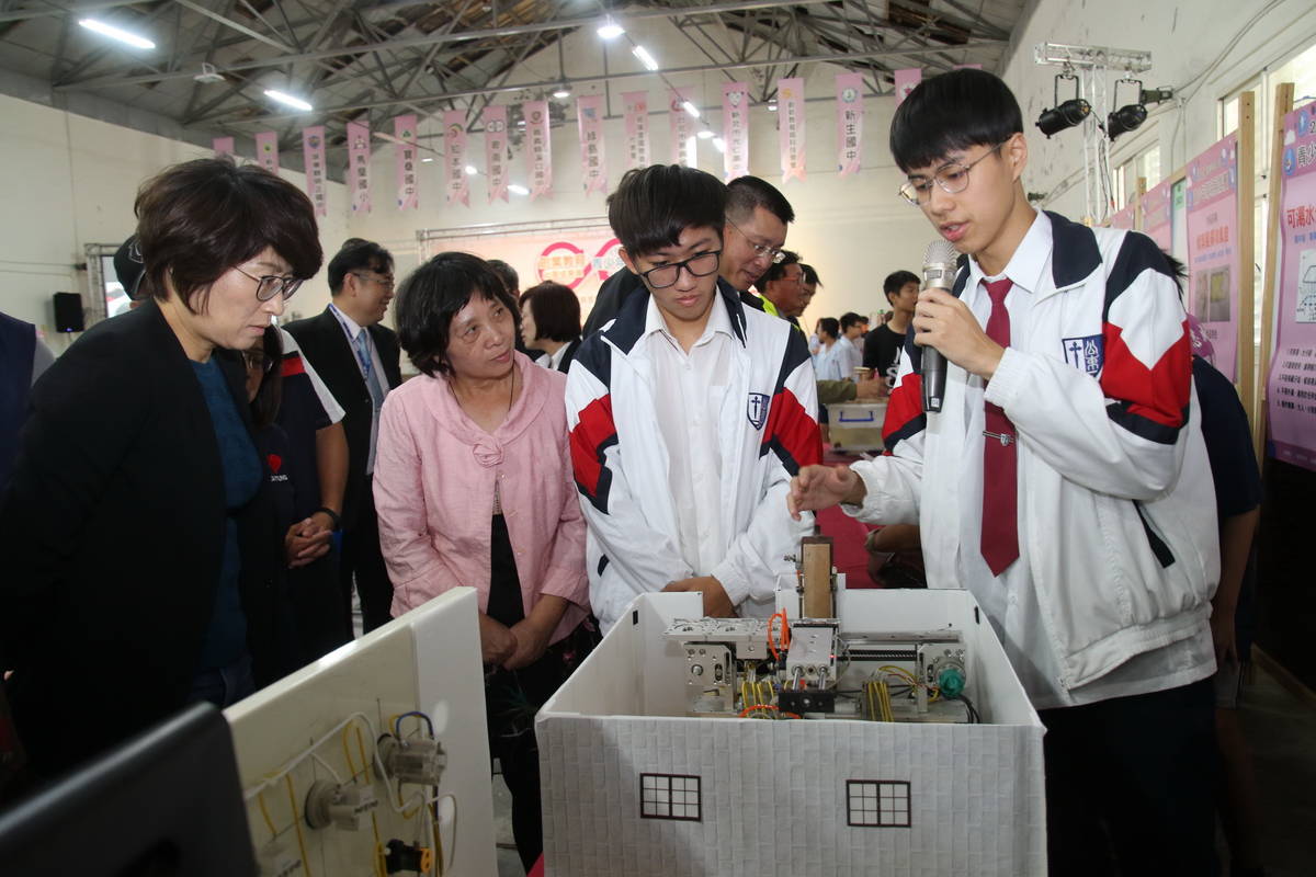 公東高工學生向饒縣長(左)說明展出的發明作品