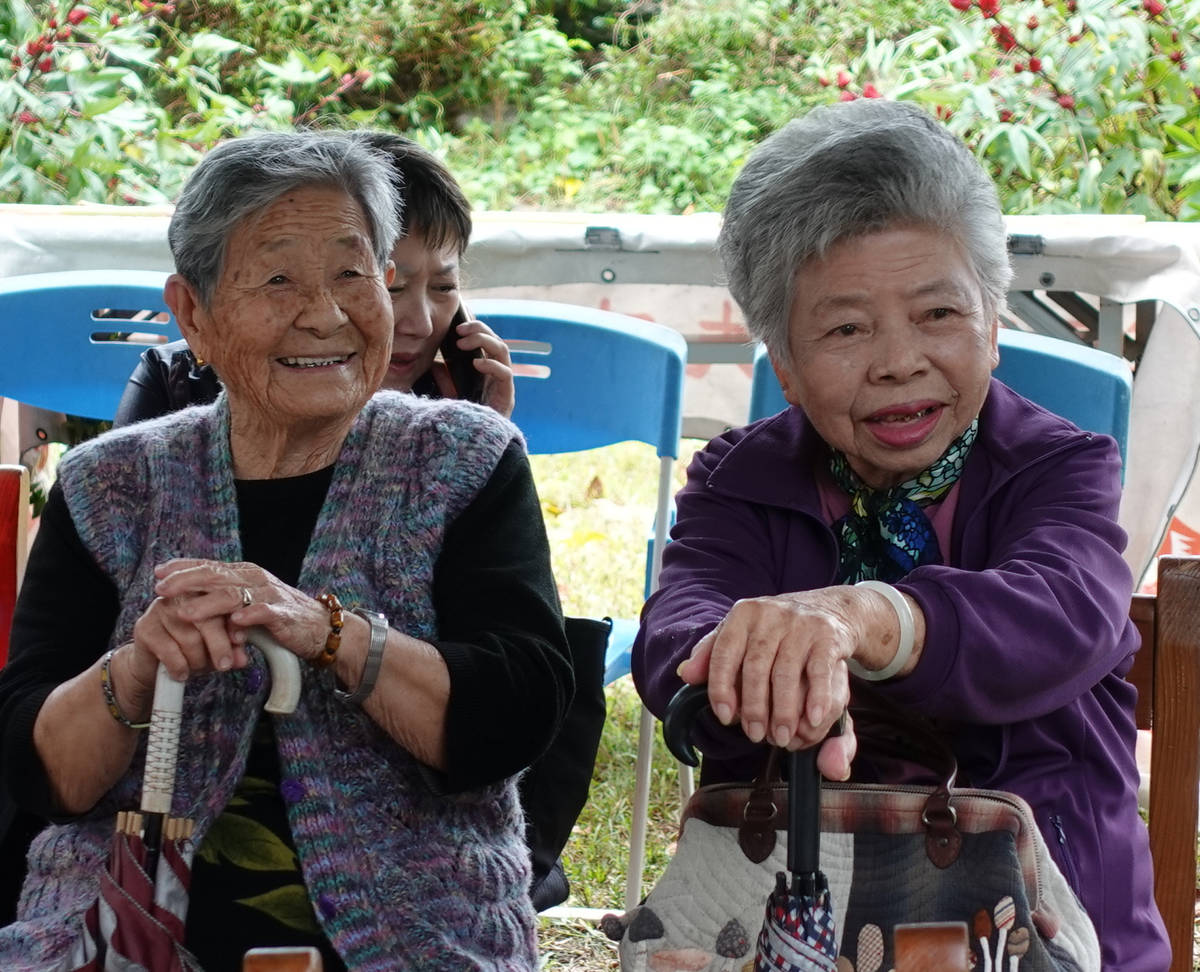 「龍田村百年移民史」受訪者94歲的潘陳約阿嬤(左)與邱郁馨女士拄著拐杖參加新書發表會，兩人神情都相當歡喜。