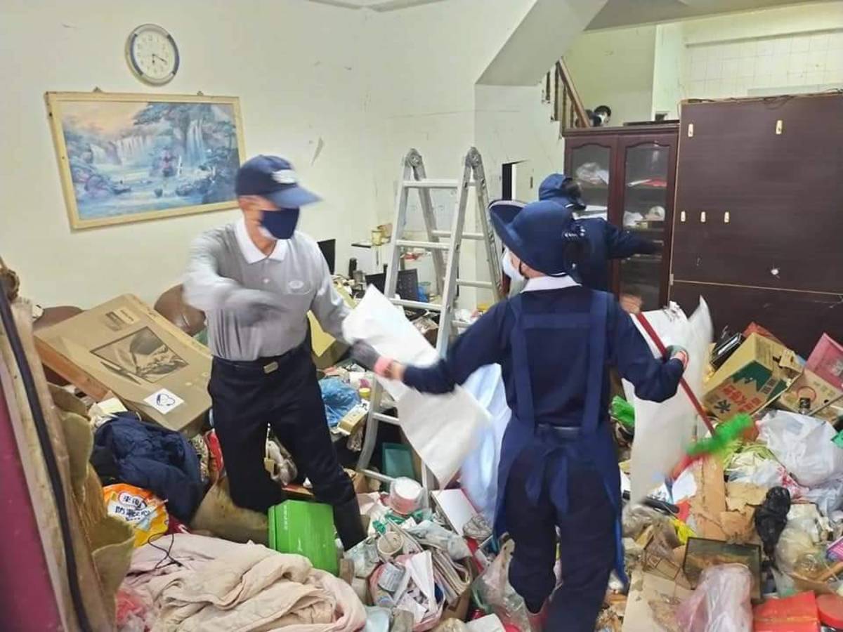 林坤旺(左)9月到弱勢家庭中清掃堆積如山的垃圾。(圖為慈濟基金會提供)
