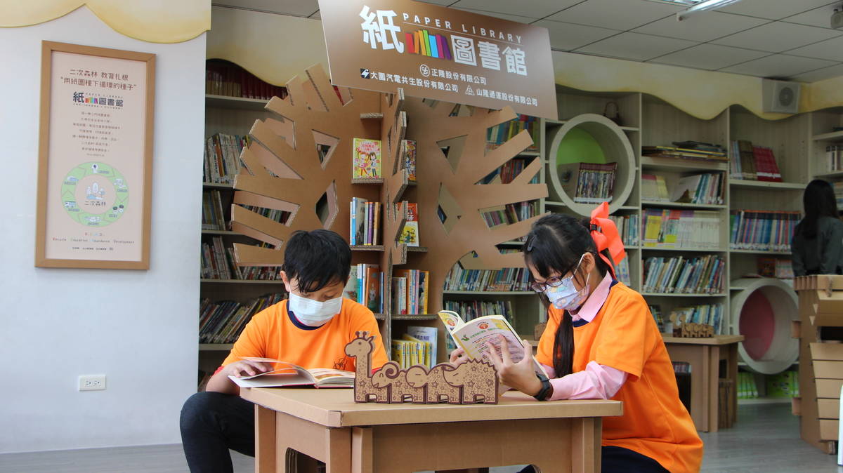 積穗國小學生徜徉在紙圖書館閱讀世界。