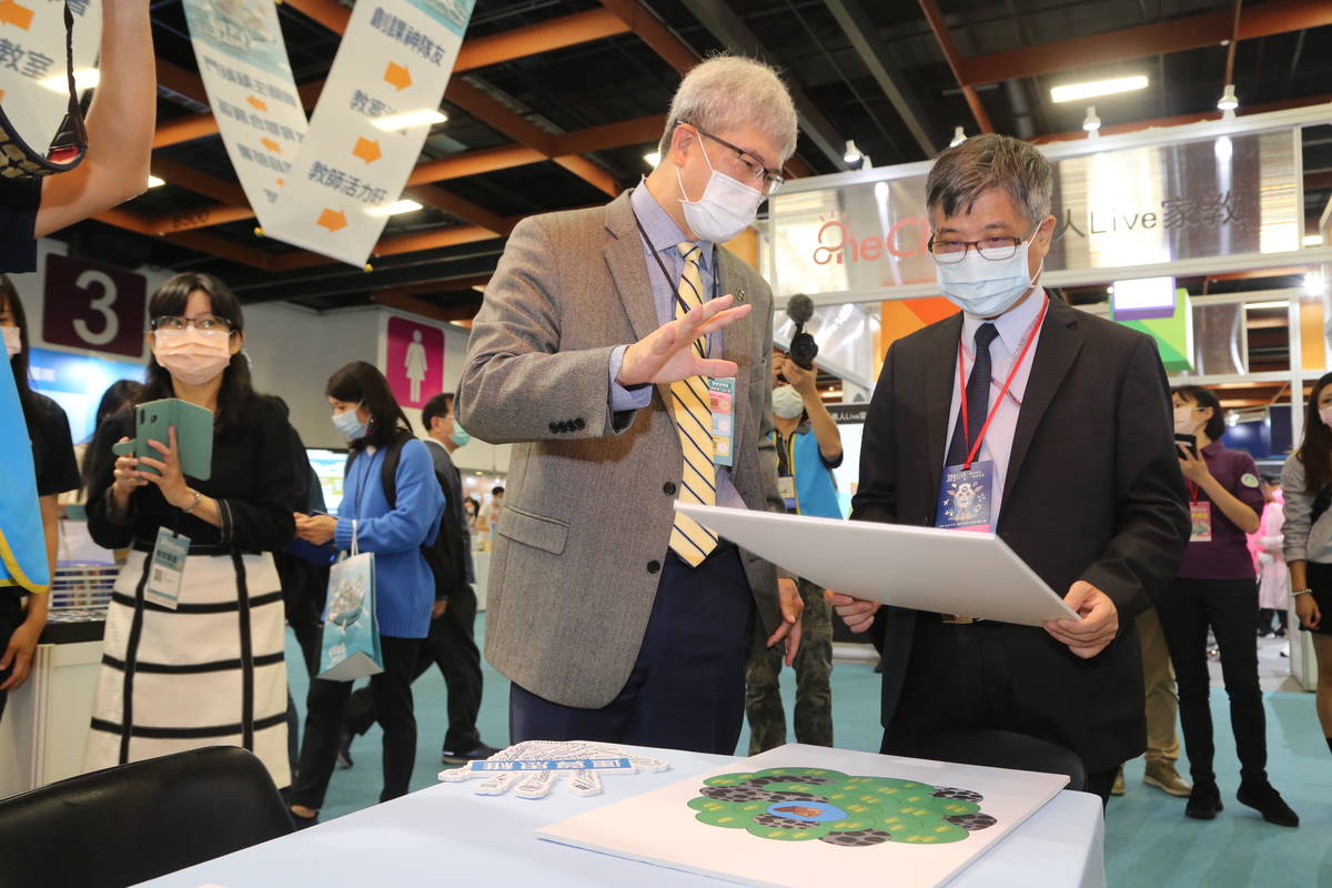 教育部次長劉孟奇(左)參觀臺灣教育科技展，聽取特色學校介紹。