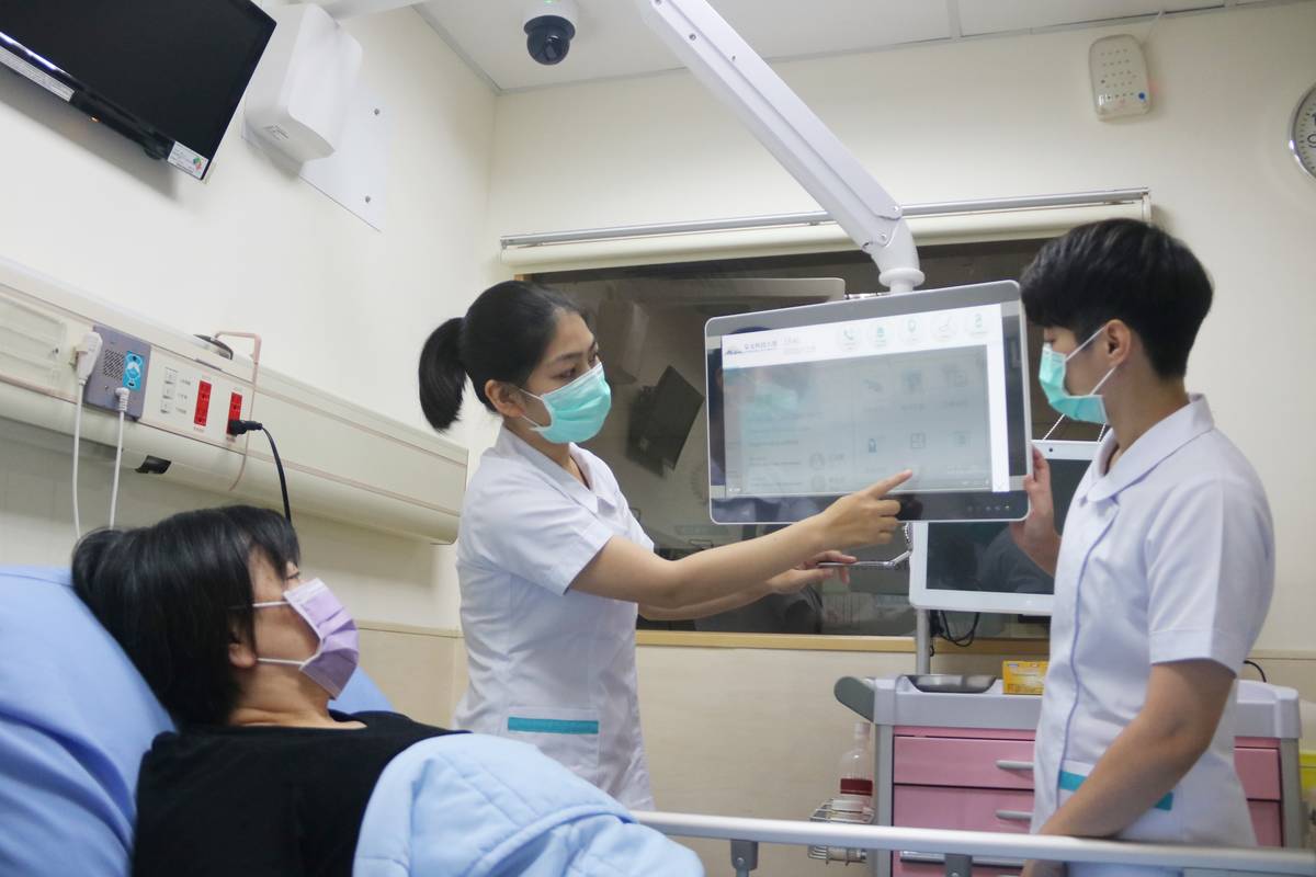 學生以懸臂式電子白板向病患宣導衛教（圖片來源：弘光科技大學）