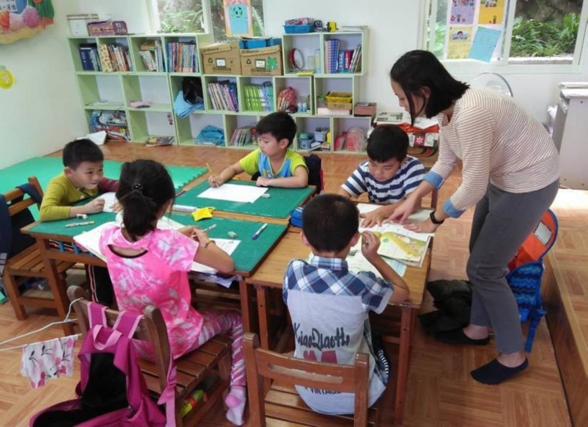 濂洞國小老師指導課後班學生作業。