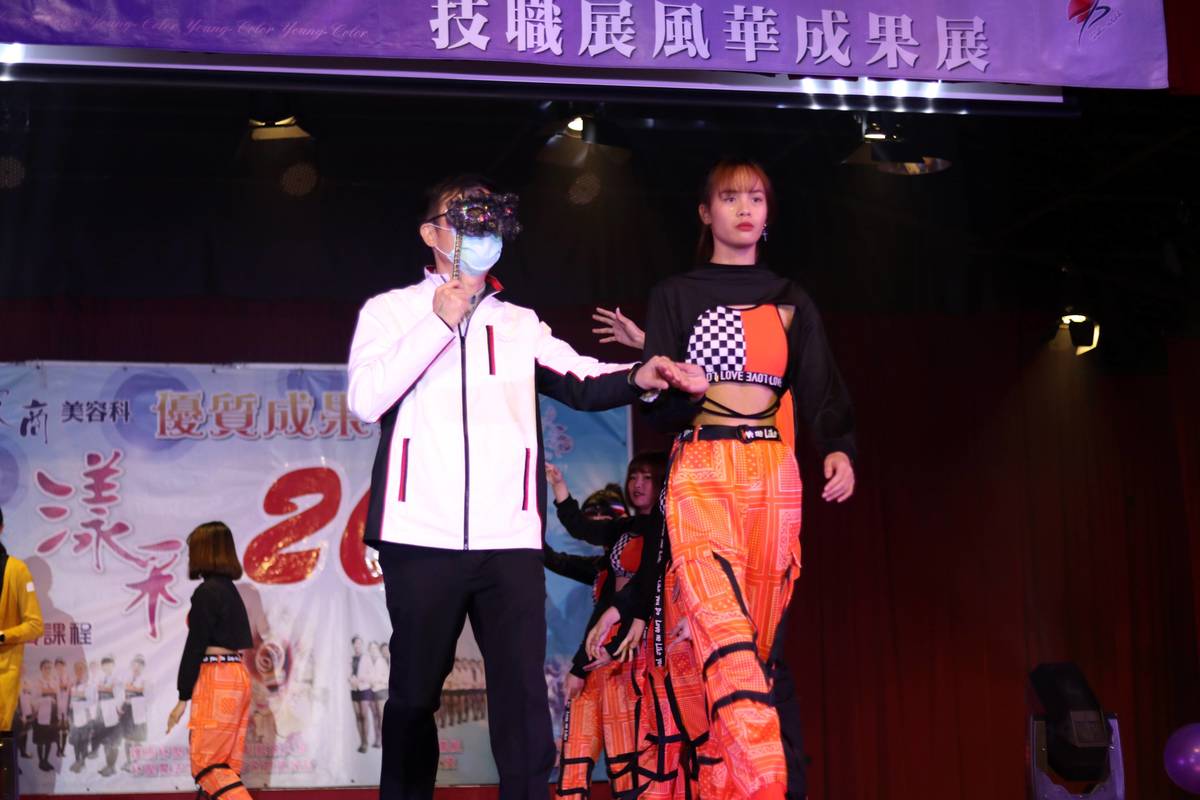 張明文局長配戴選手蕭書涵同學親手製作神秘面具一起與學生走上伸展台。