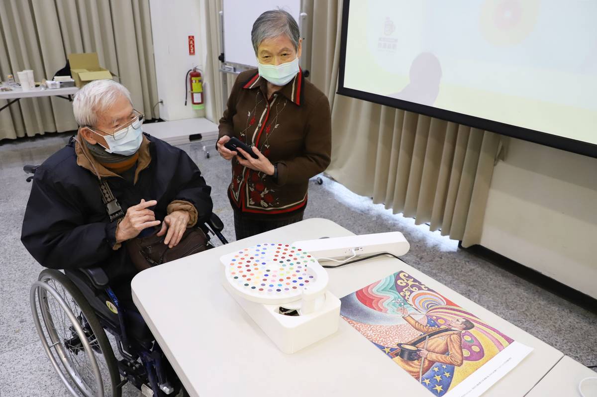 長輩們體驗由臺科大團隊打造的「色彩唱盤機」，能夠感應唱盤上的顏色，播放出不同顏色對應的聲音