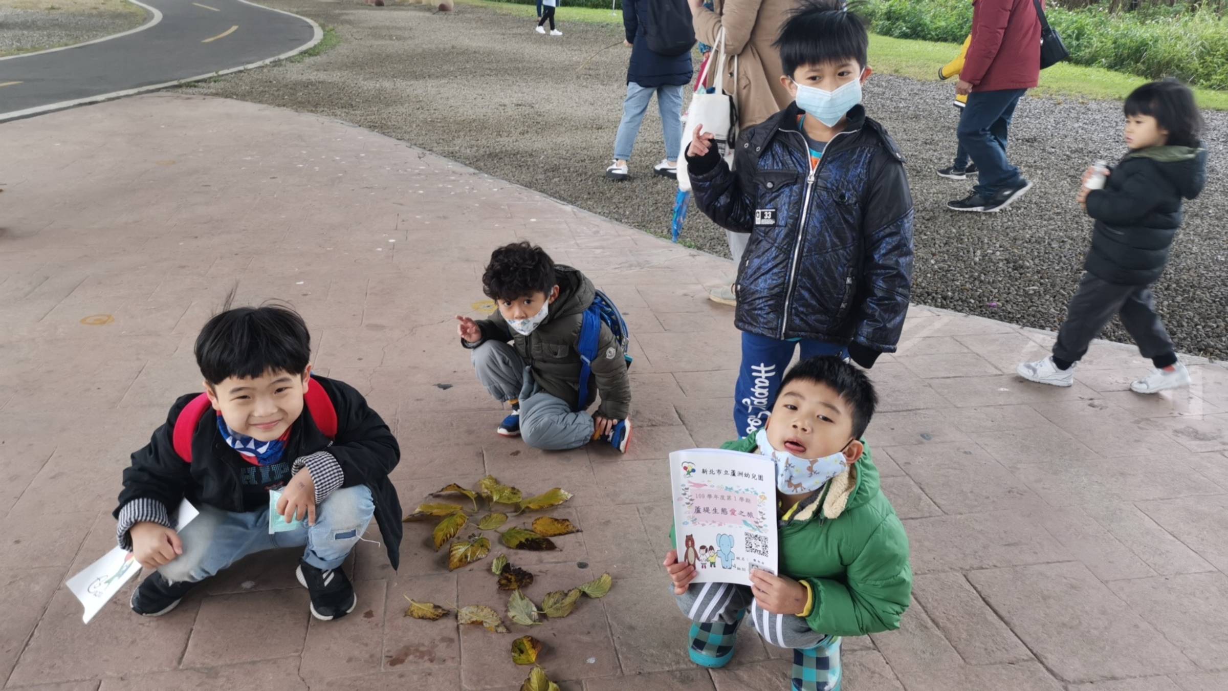 幼生在公園裡撿拾落葉即興鋪排創作。
