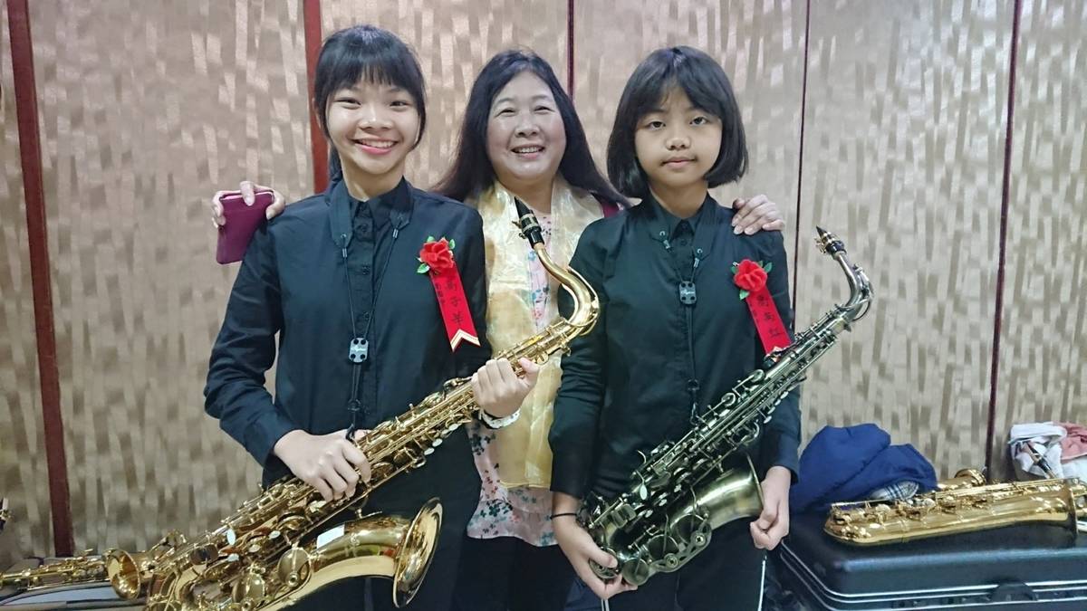 卑南國中學生高子莘(左)和妹妹高禹虹(右)同獲臺東區普仁獎，與校長游數珠(中)開心合影。