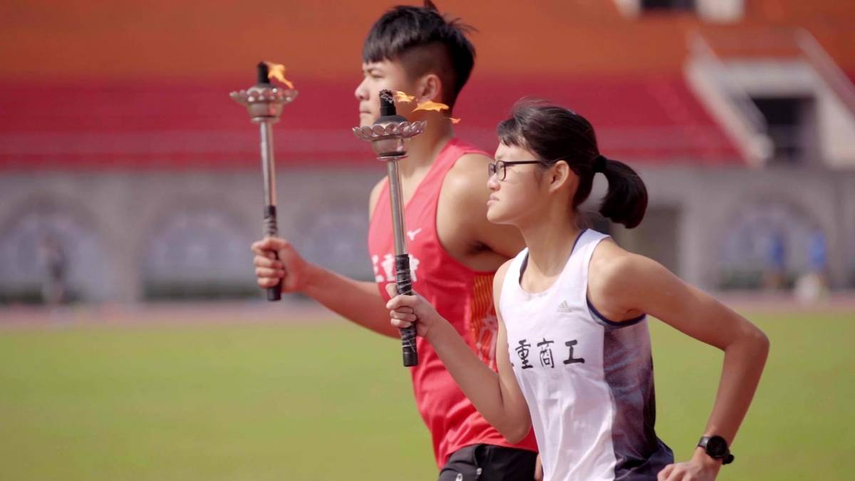 新北巿中小學運動會聖火由三重高中陳宜助(左)；三重商工吳昕芳(右)代表傳遞。