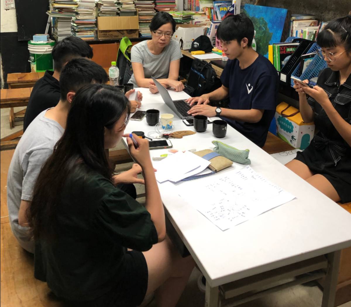 「火金菇」團隊成員在螢火蟲書屋裡討論。