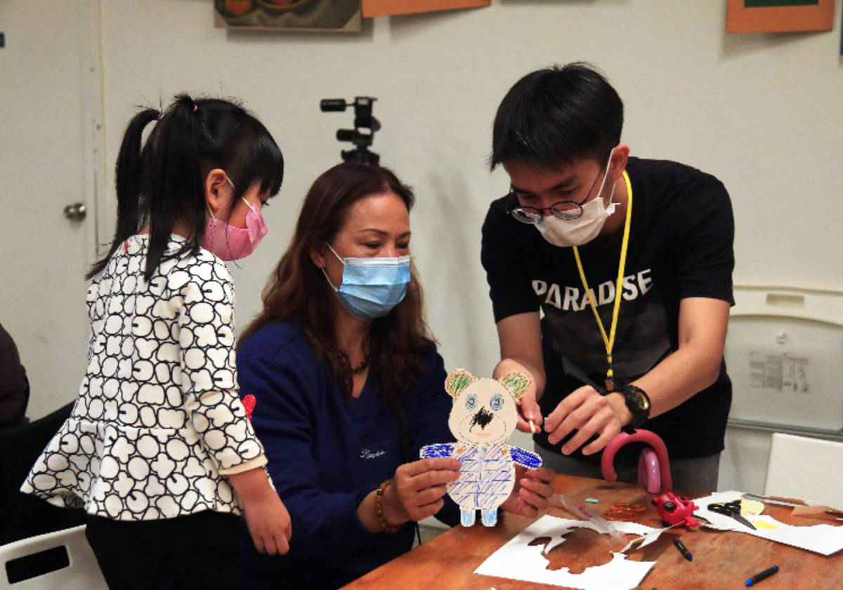 龍華科大學生跨域團隊辦皮影戲手作坊，耐心教家長與小朋友製作(龍華科大提供)