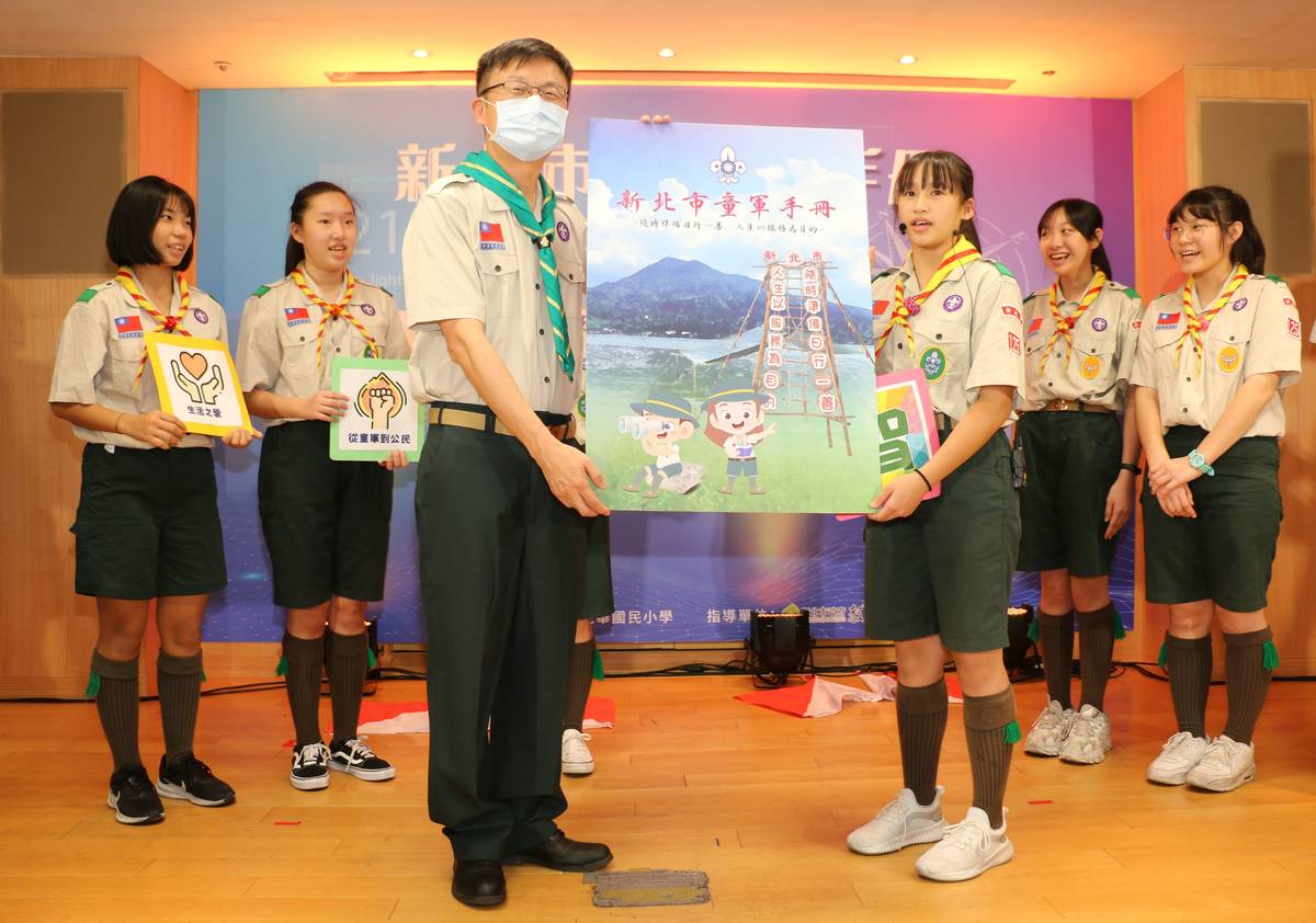 張明文局長頒贈新北市童軍手冊給童軍團學生。
