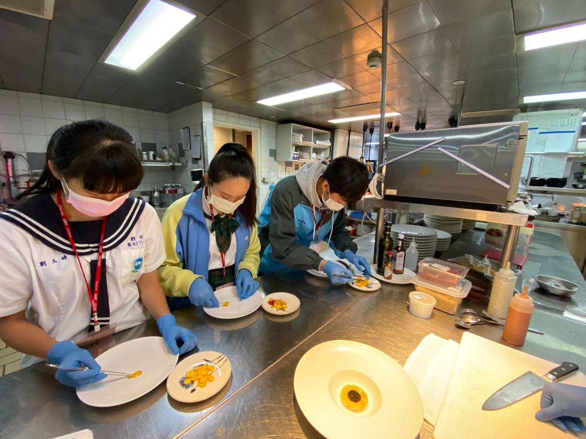 寶艾西餐廳主廚教導學生用南瓜片製作太陽花前菜。