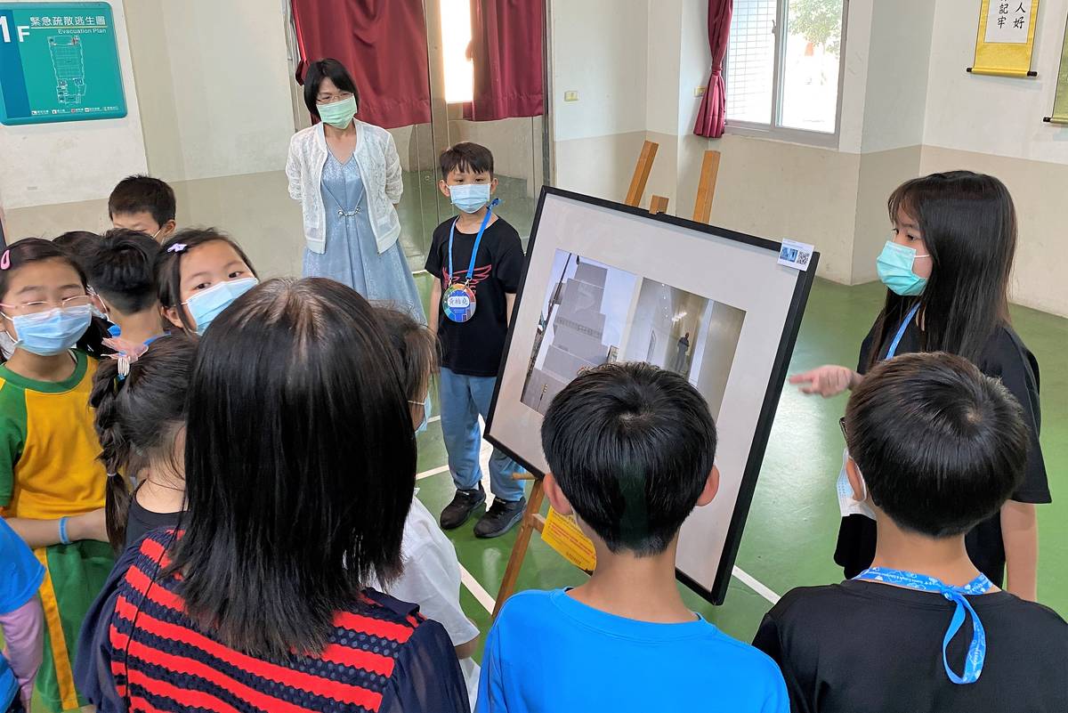 來參觀展覽的學生認真聽解說員講解作品