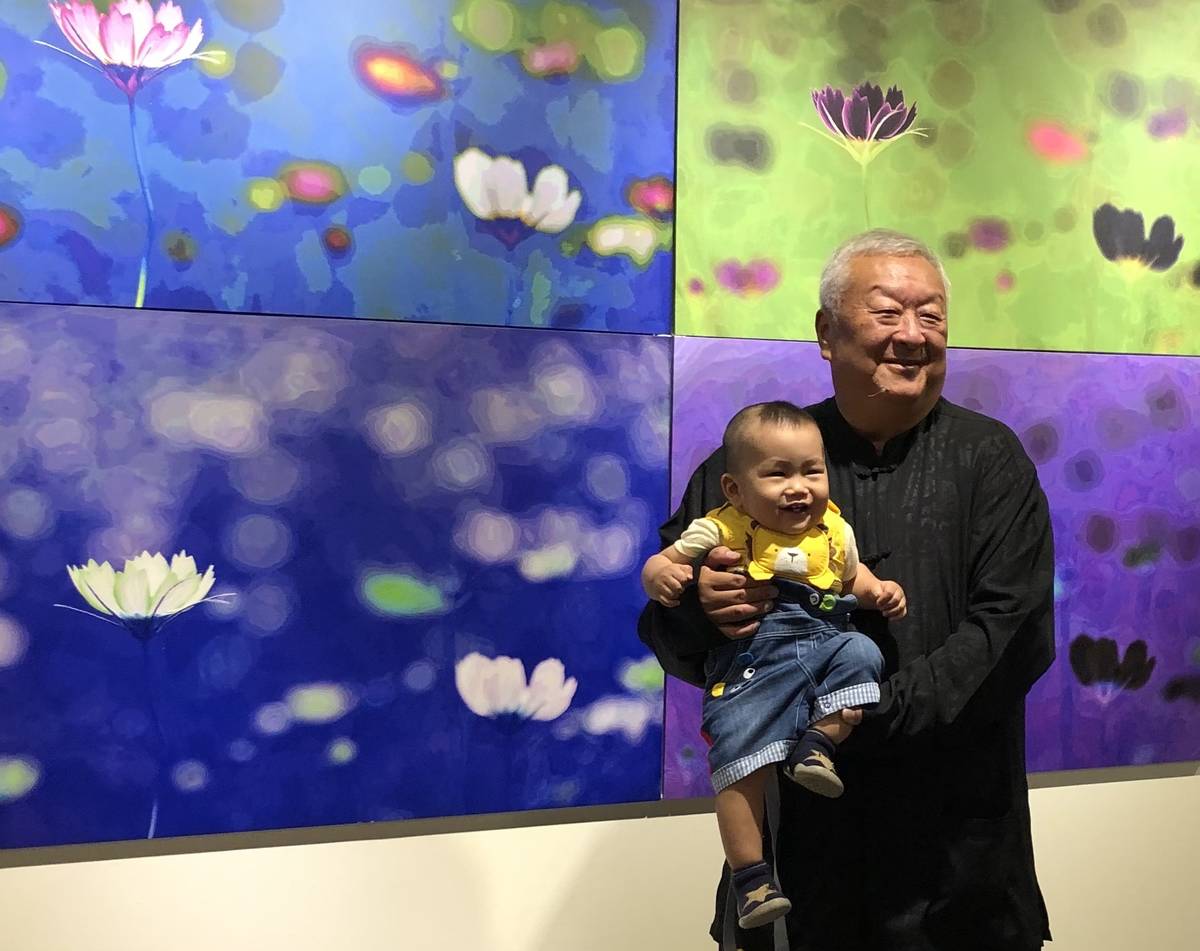 徐明正應友人之託，像阿公一樣，抱起可愛的小娃娃合影。