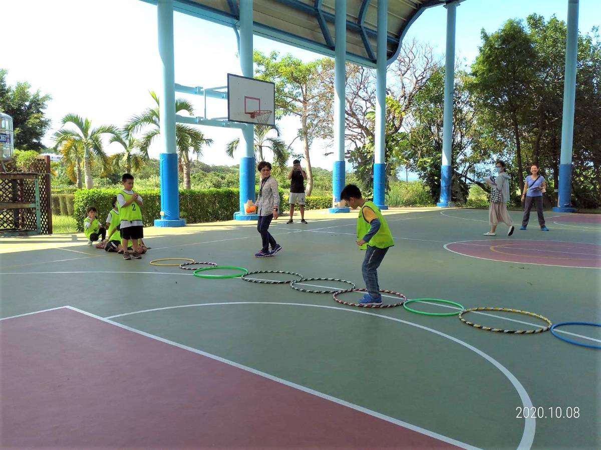 屯山國小校長鄒惠娟在體育課帶領孩童進行「攻城堡」遊戲。