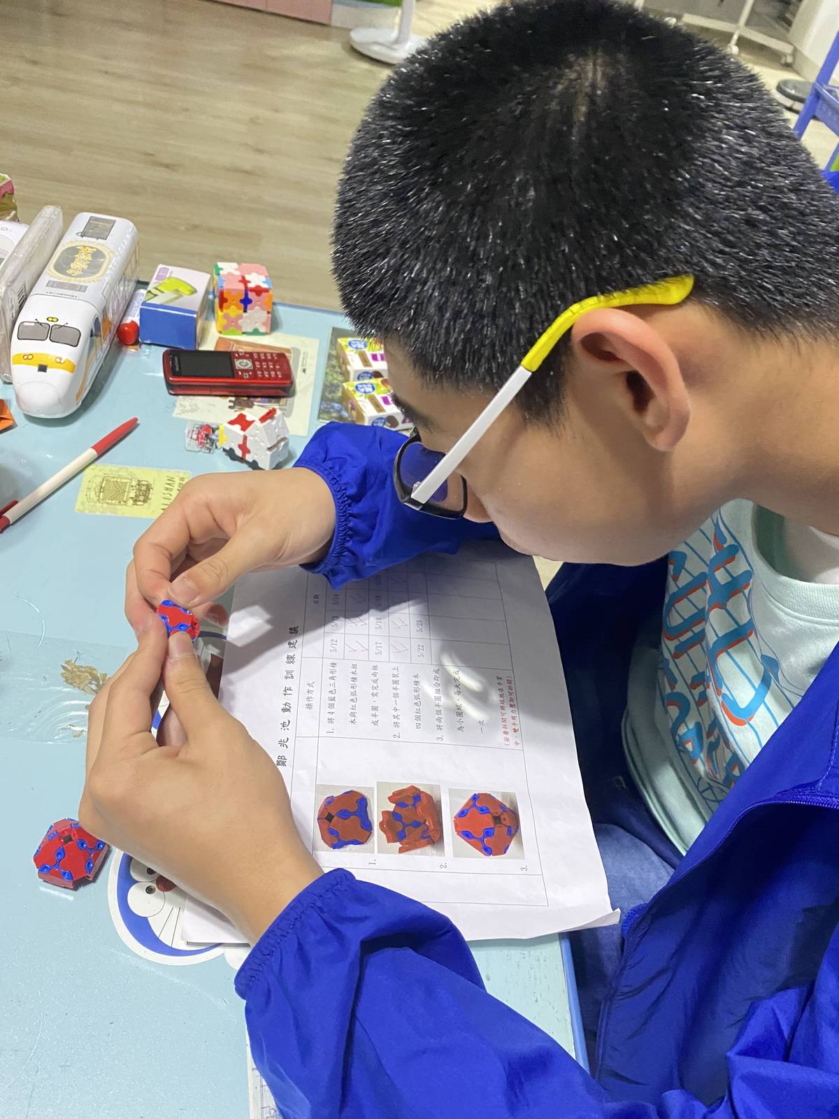 新北特教學校學生喜藏(化名)專注地運用老師寄來的教材，配合線上說明，進行職能訓練。