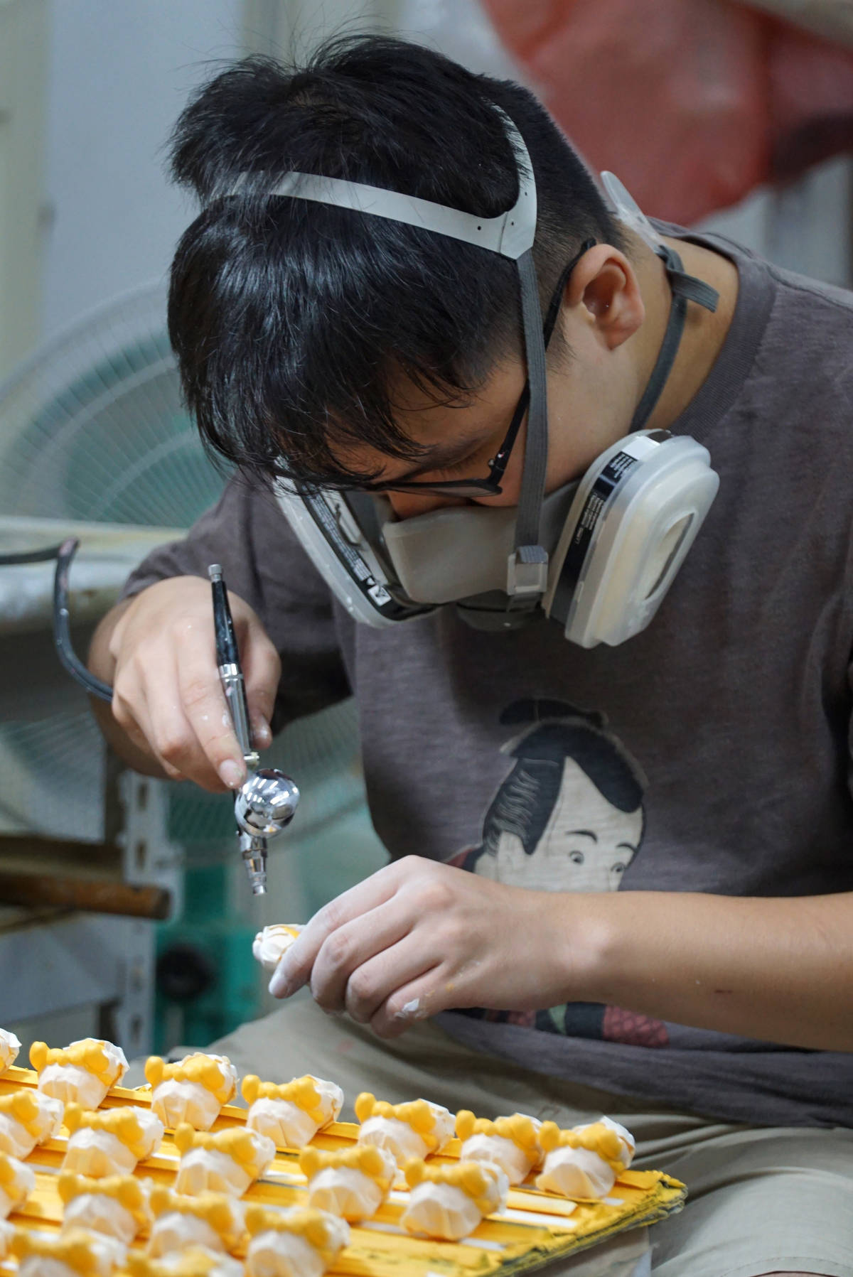 大葉大學多媒體學程學生陳鼎文幫公仔噴漆上色(圖片來源：大葉大學提供)