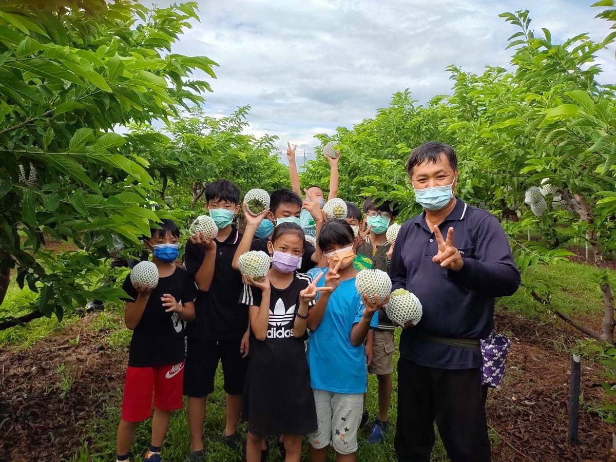 每位小朋友拿著像自己的臉一樣大的釋迦合照