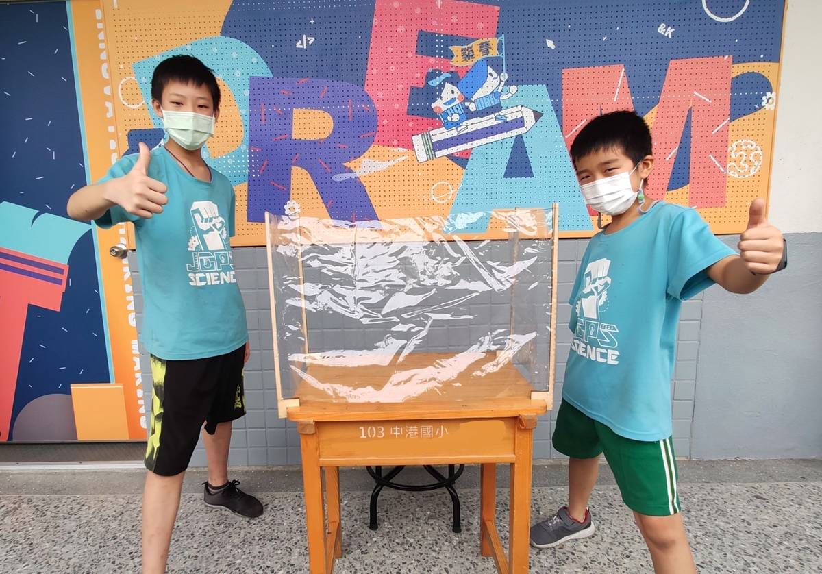 中港國小學生孫鈺荃(左)與楊正厚(右)，以「露營」、「帳篷」為發想，透過椴木板與透明塑膠布設計出方便攜帶、容易組裝及收納的露營風防疫隔板。