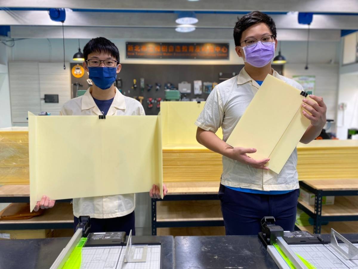 樟樹國際實中蔡釋鋒老師及學生林泰翔(左)、吳懿峰(右)利用塑膠瓦楞板自製隔板，送給七年級及高一新生作為歡迎新生踏入樟樹校園的第一份賀禮。