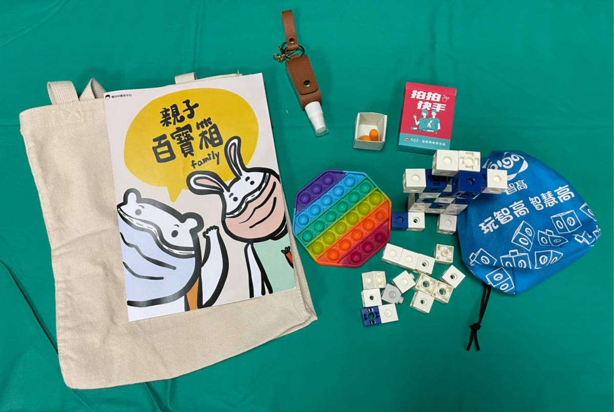中心首創親子百寶箱，內有酒精噴瓶鑰匙圈、出氣包(耳塞、紓壓小物滅鼠先鋒)、桌遊卡牌、益智積木和宣導文宣。(南臺中家扶提供)
