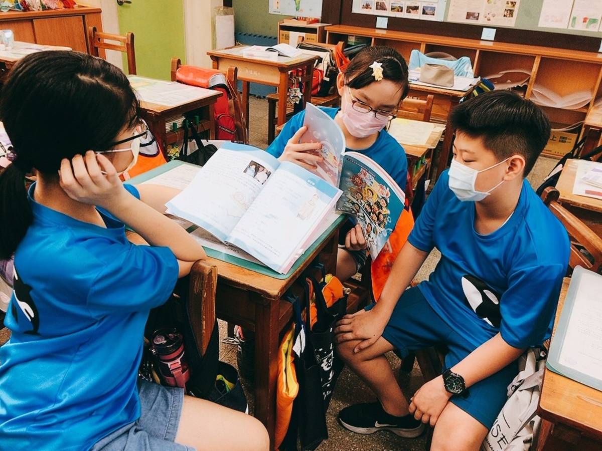 板橋國小學生課後翻閱擁夢飛翔書籍並熱烈討論